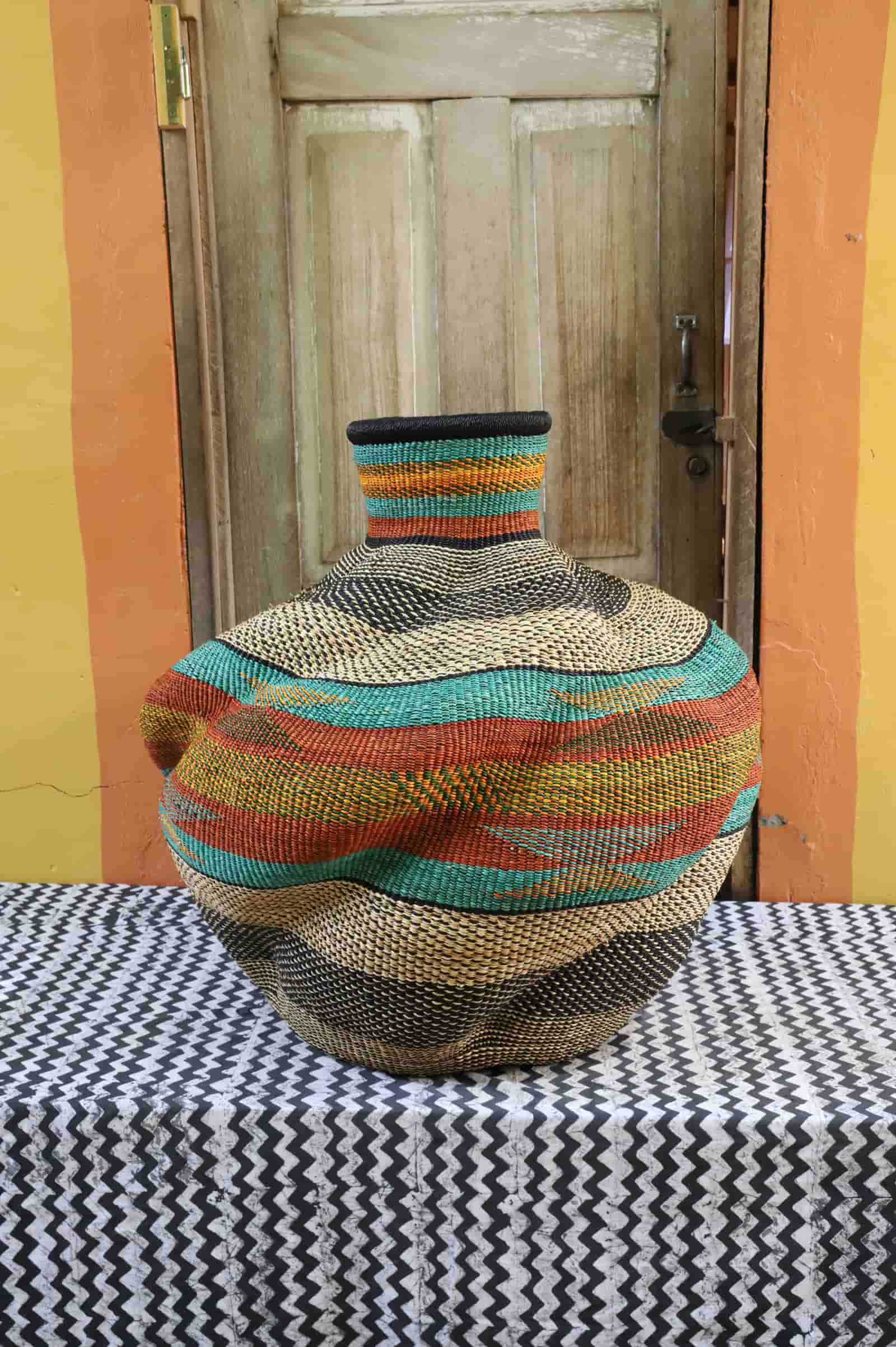 Colorful woven basket on a table with a wooden door in the background
