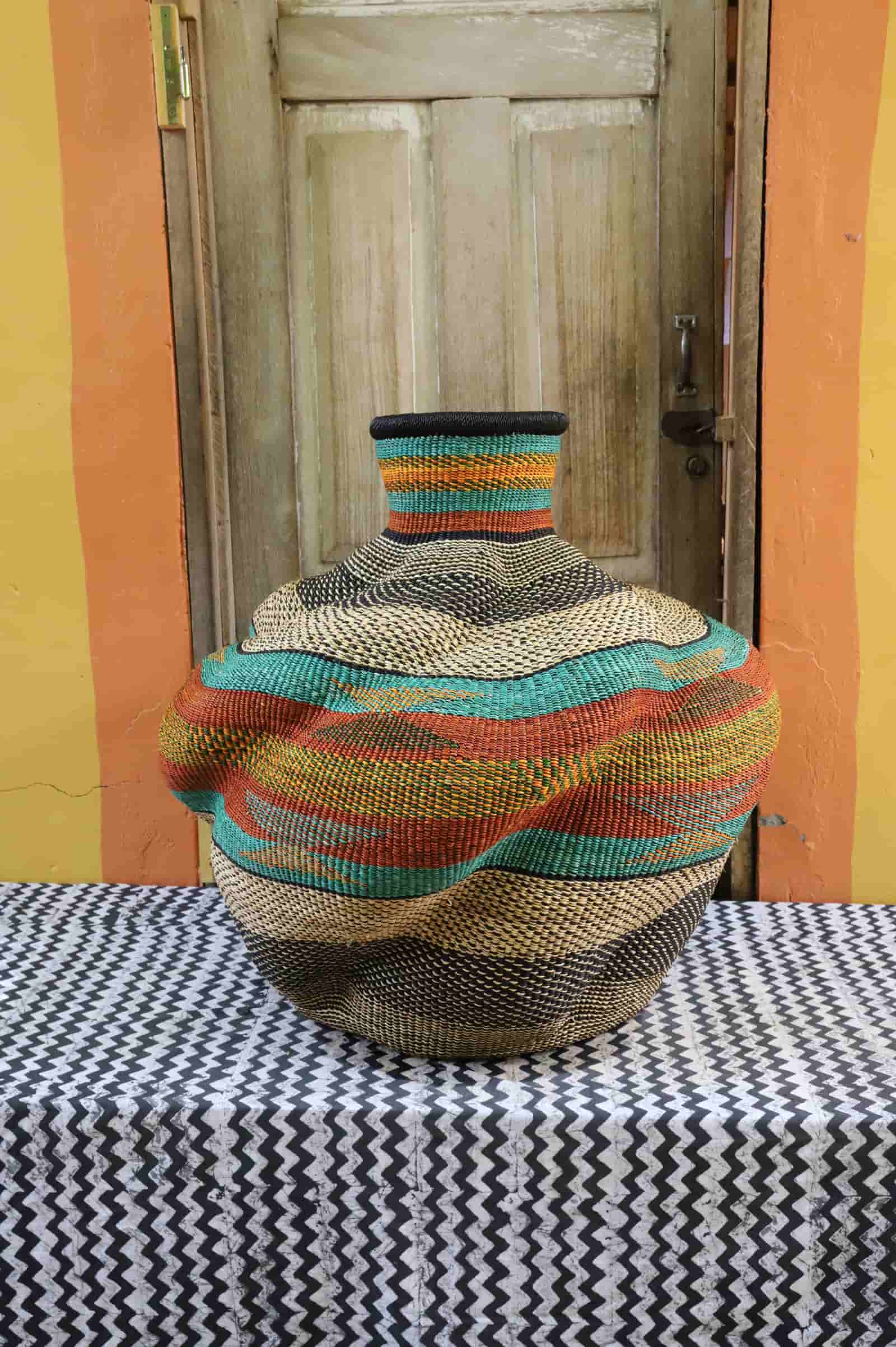 Colorful woven basket on a table with a wooden door in the background