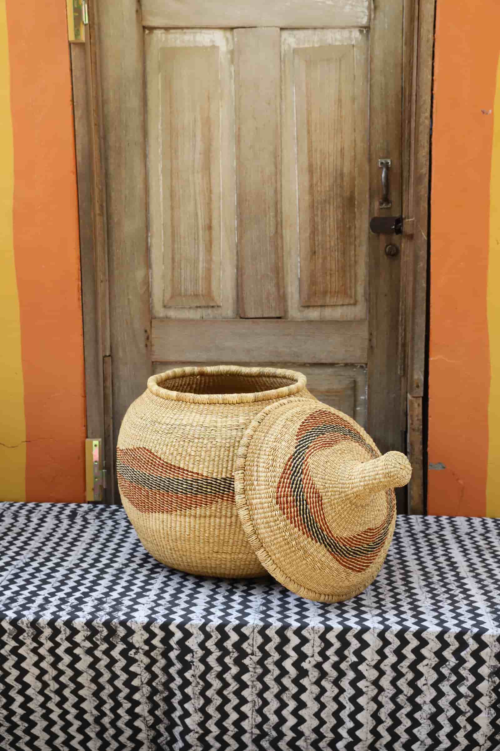 Large Orbit storage basket in natural straw with rust diagonal swirl, lid off to the side