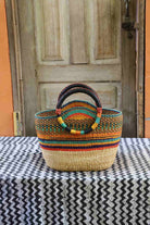 Colorful woven basket on a black and white patterned tablecloth with a wooden door in the background.