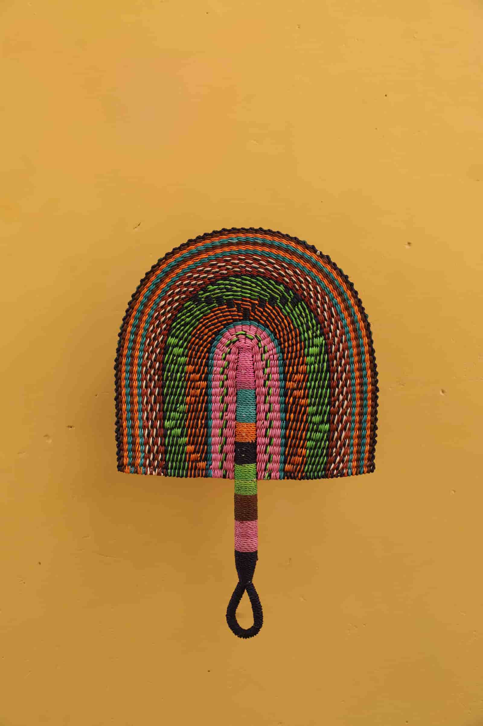 Colorful hand-woven broom on a yellow background