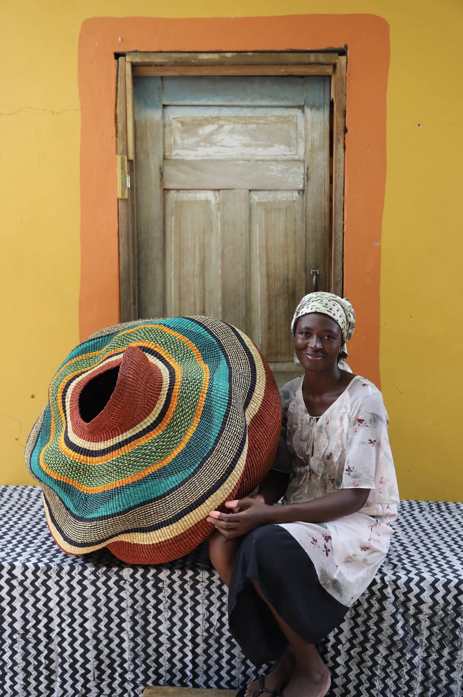 Perpetual “Pepe” Adagaam seated beside the Katayeli-Tia basket credited to her in The Baba Tree’s product catalogue.