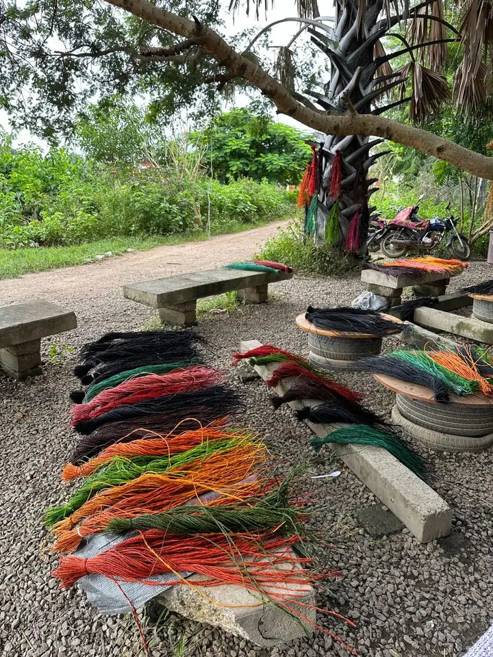 Bundles of dyed straw spread out at the compound