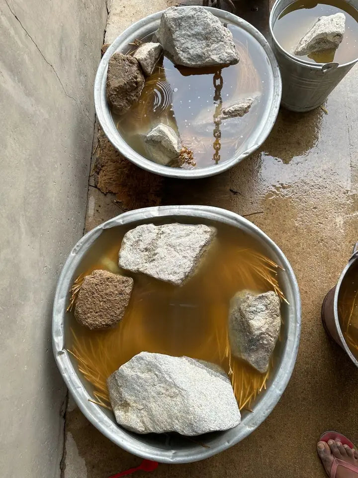 Natural straw soaking under stones in metal bowls