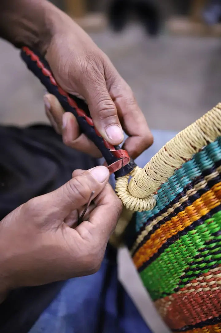 Close view of hands fitting leather around a basket handle