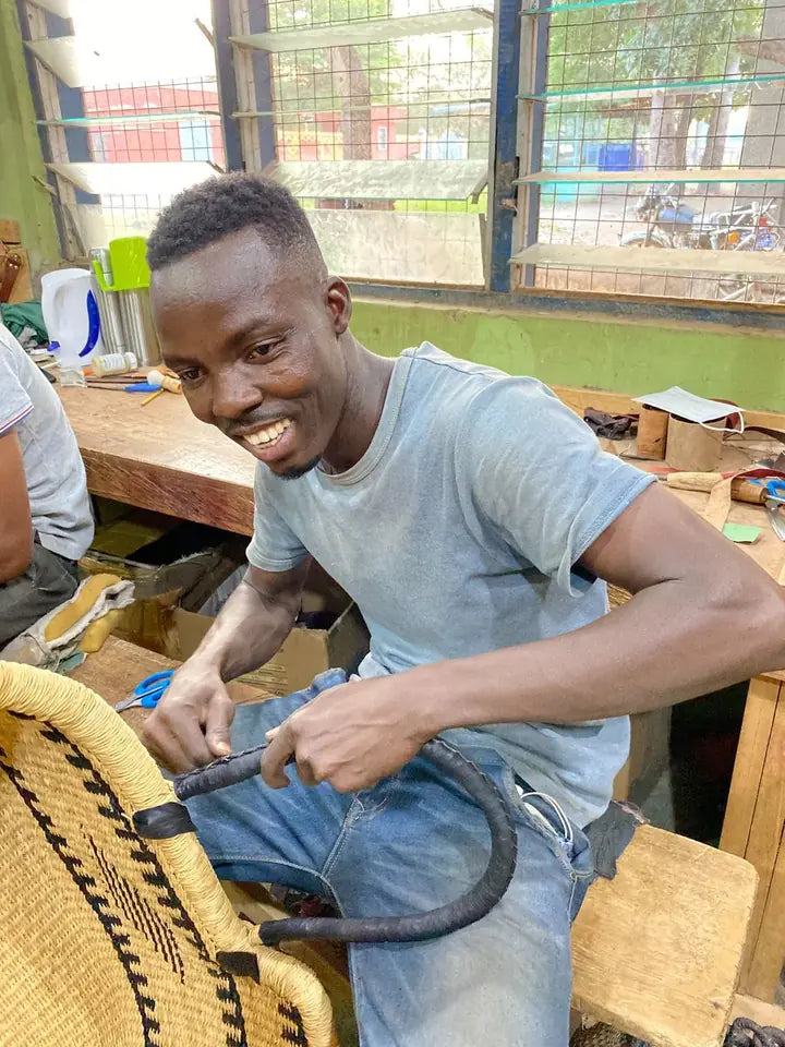 A leather worker finishing a leather covered basket handle