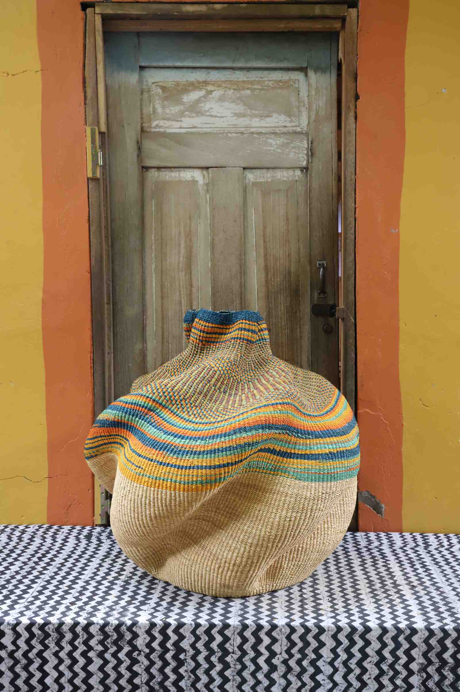 Large handwoven Bolga art basket in a sculpted natural straw pot with a multicolour banded shoulder.