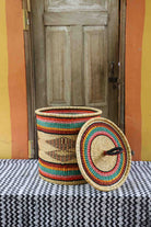 Handwoven Bolga laundry basket with lid removed, natural body with fine multicolour bands and matching lid.