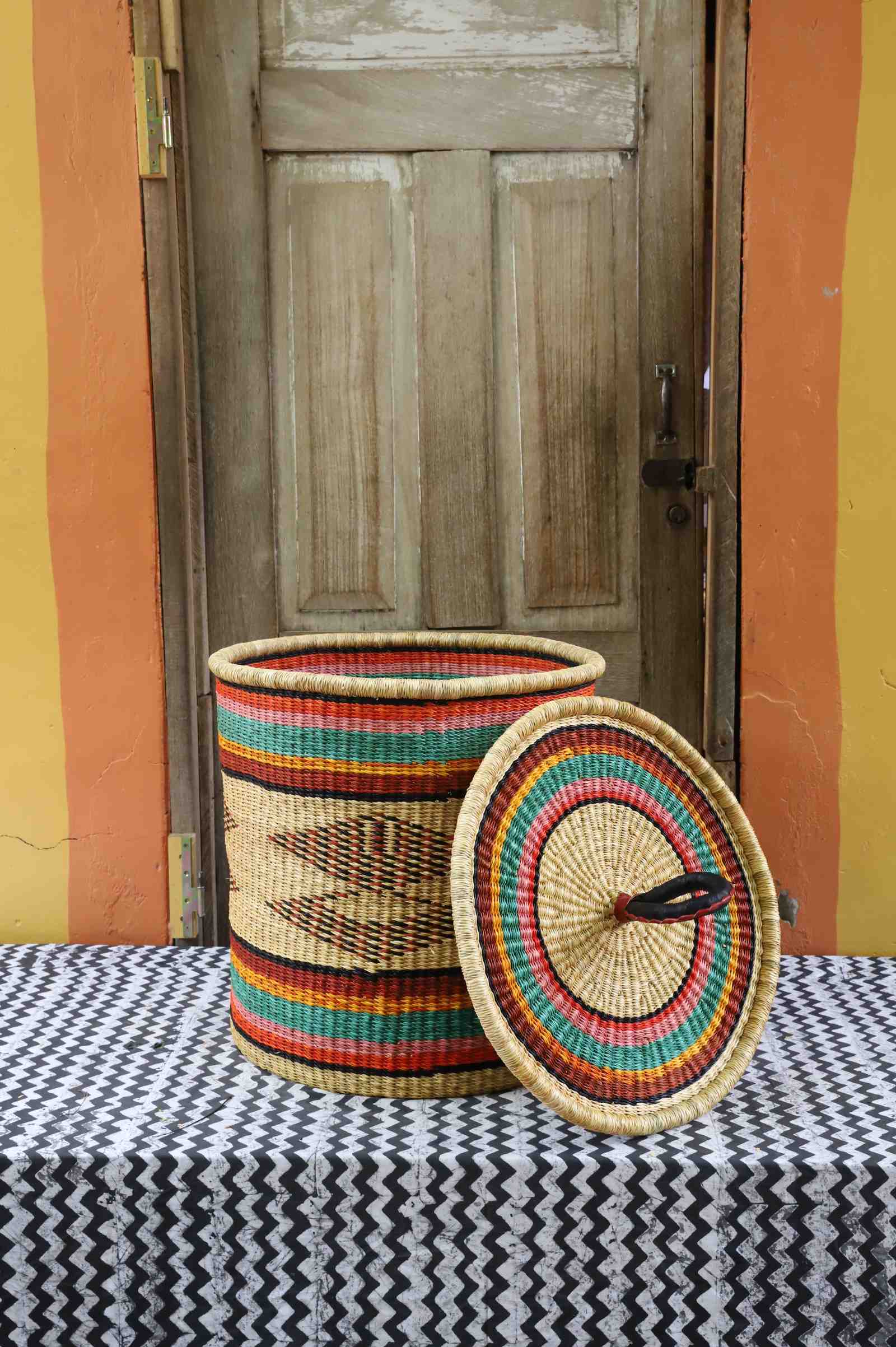 Handwoven Bolga laundry basket with lid removed, natural body with fine multicolour bands and matching lid.