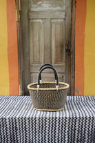 Large handwoven oval Bolga shopping basket in natural straw with a dark zigzag pattern and dark handles.