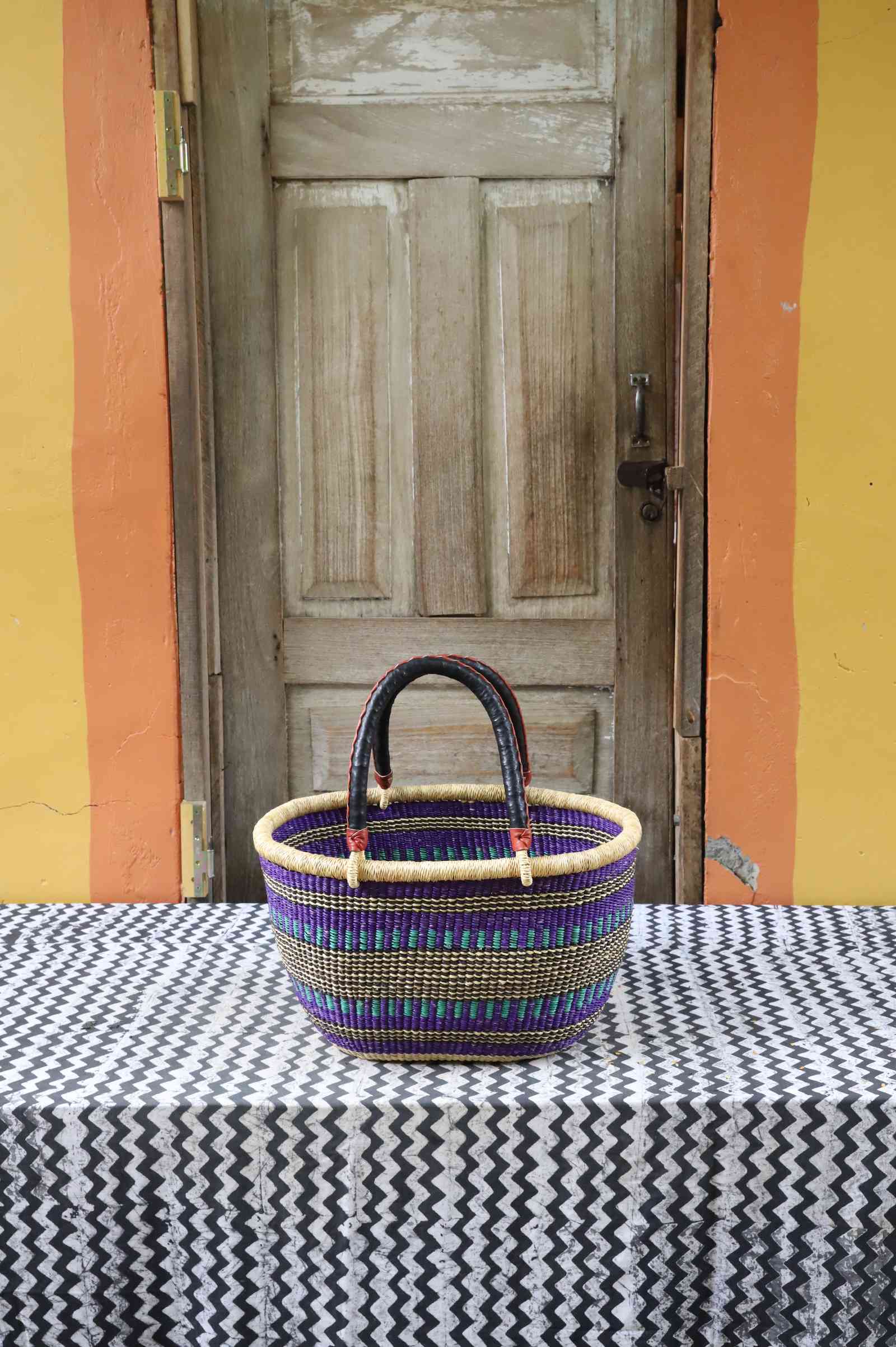 Medium handwoven oval Bolga shopping basket in natural straw with fine multicolour banded stripes.