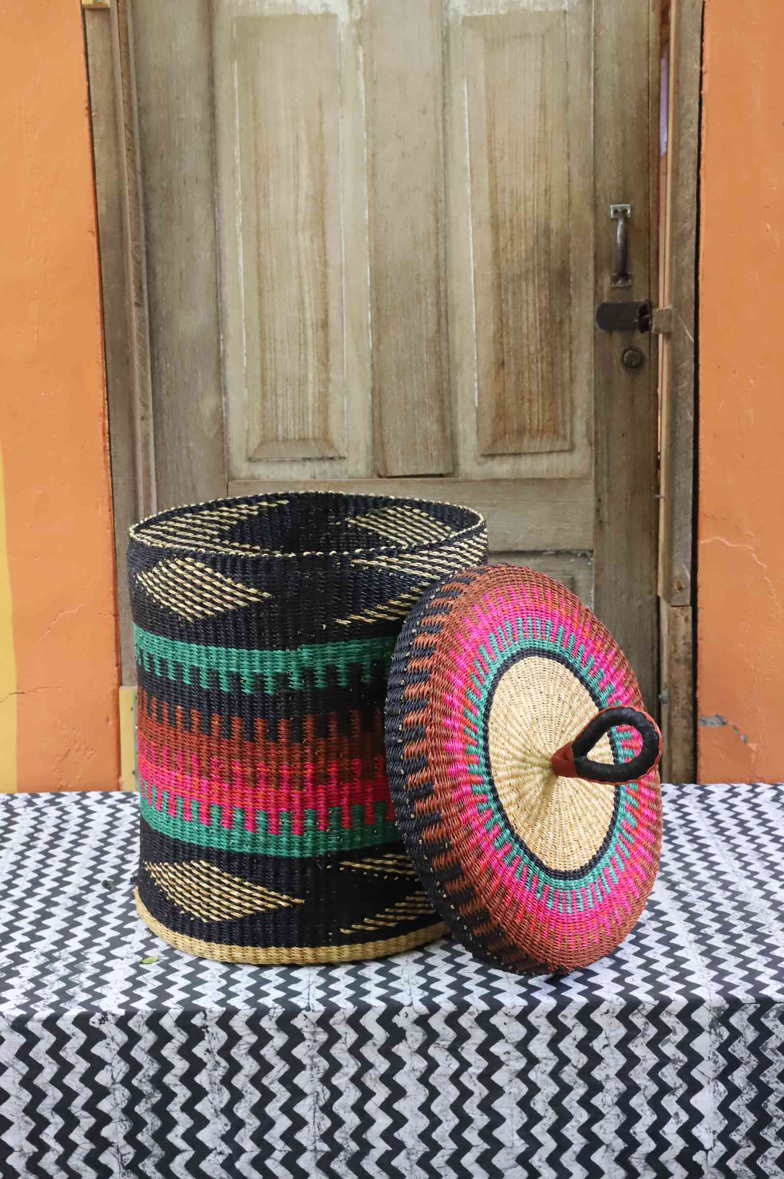 Lidded laundry basket in teal, pink and rust banded weave, lid resting alongside on a chevron cloth.