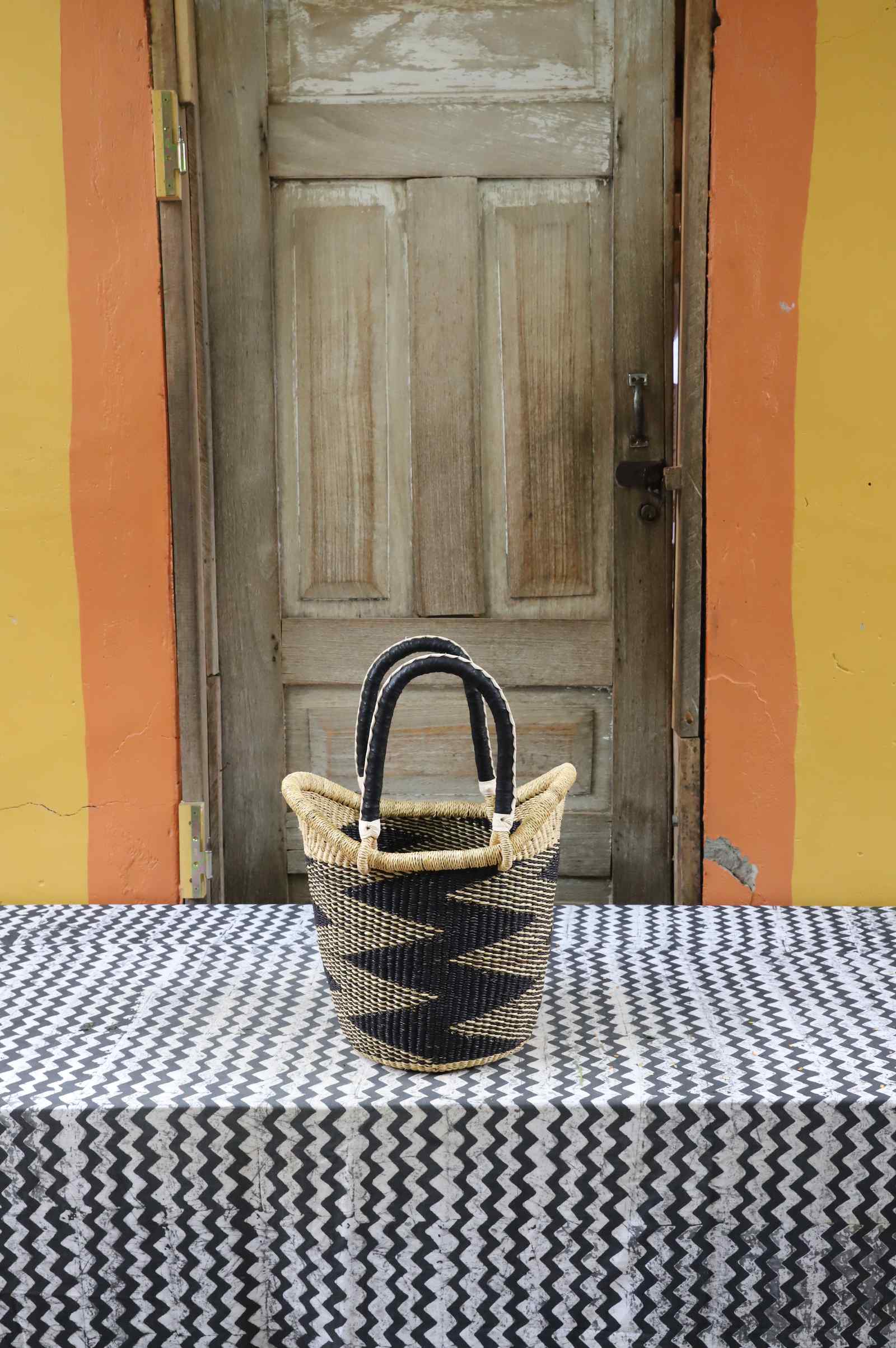 Small handwoven Nyariga Bolga shopping basket in natural straw with a bold black zigzag pattern.
