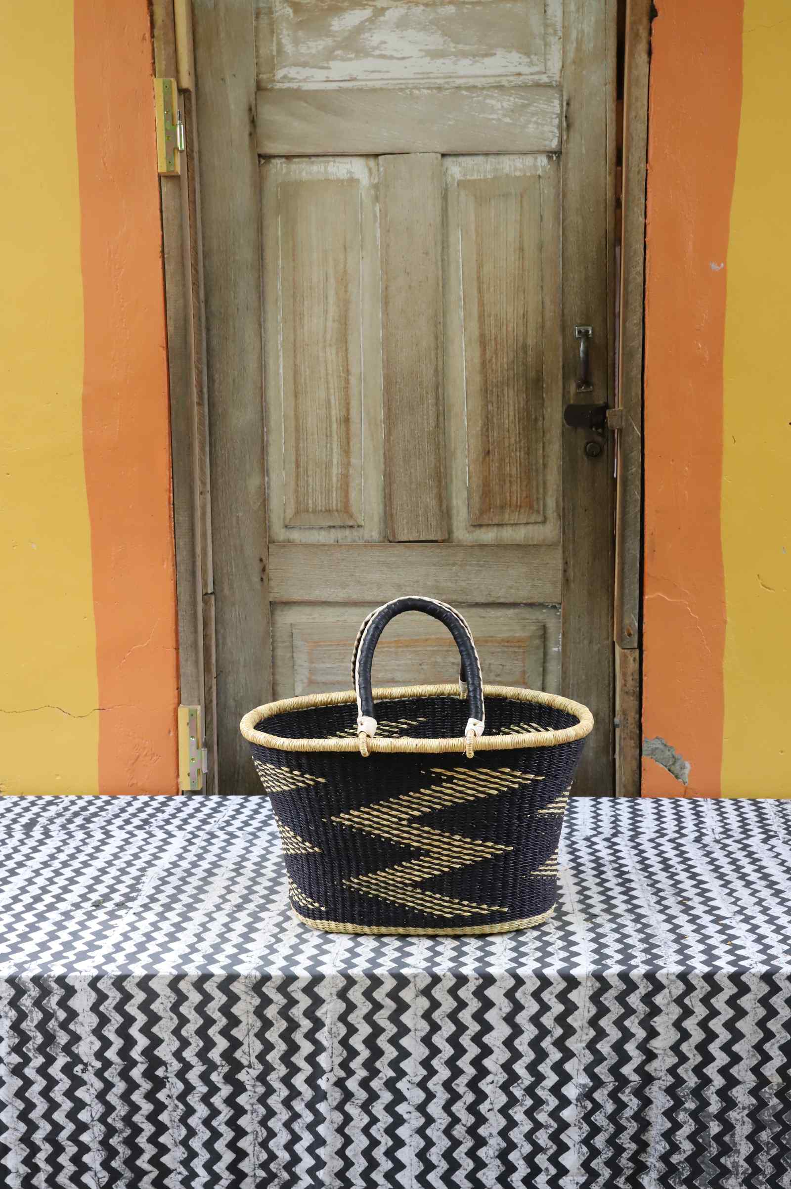 Large handwoven Bolga Zaane Tia market basket in dyed black with a natural straw zigzag weave pattern.