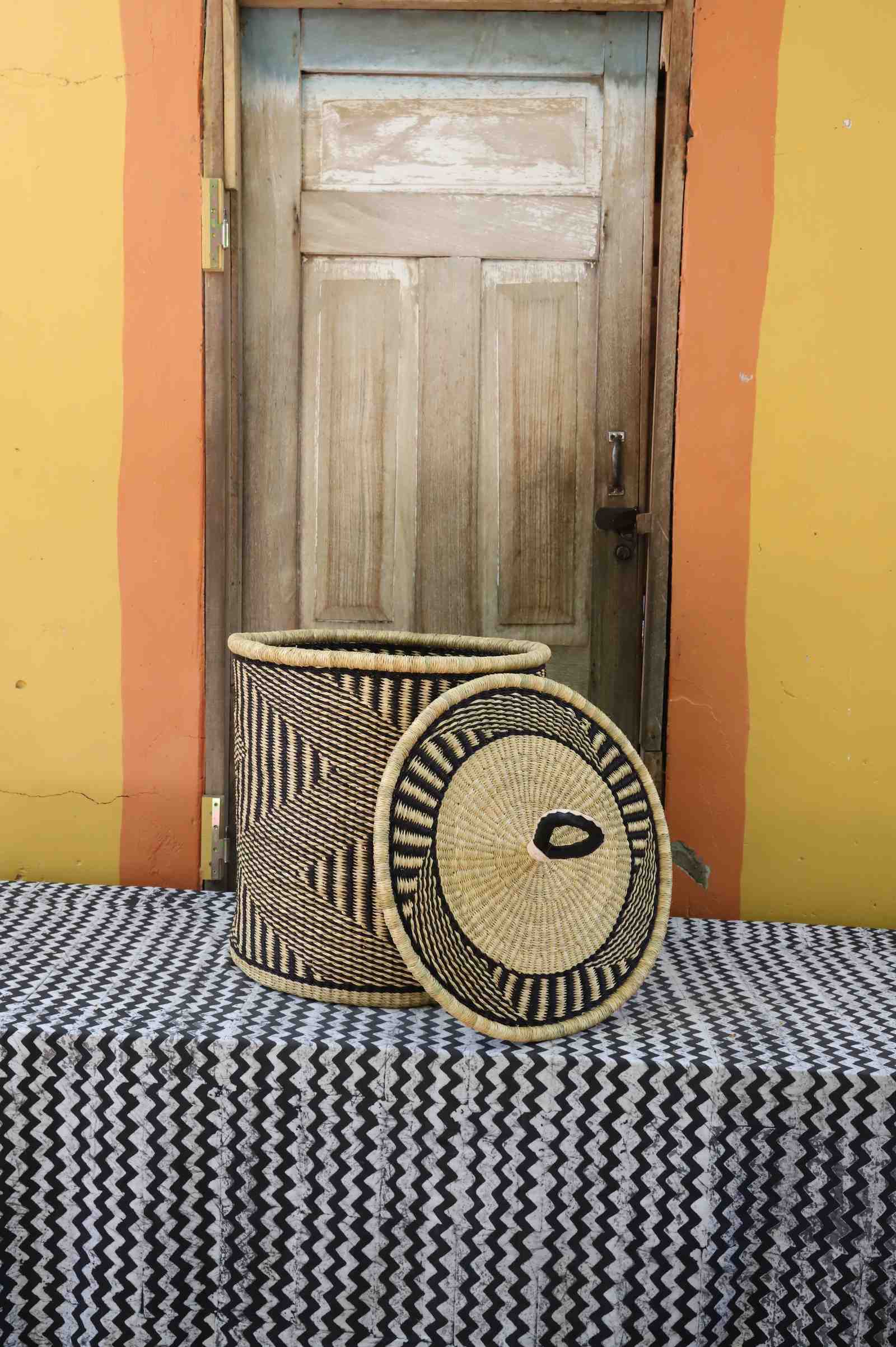 Handwoven Bolga laundry basket with lid removed, natural body with dark wave stripes and natural lid.
