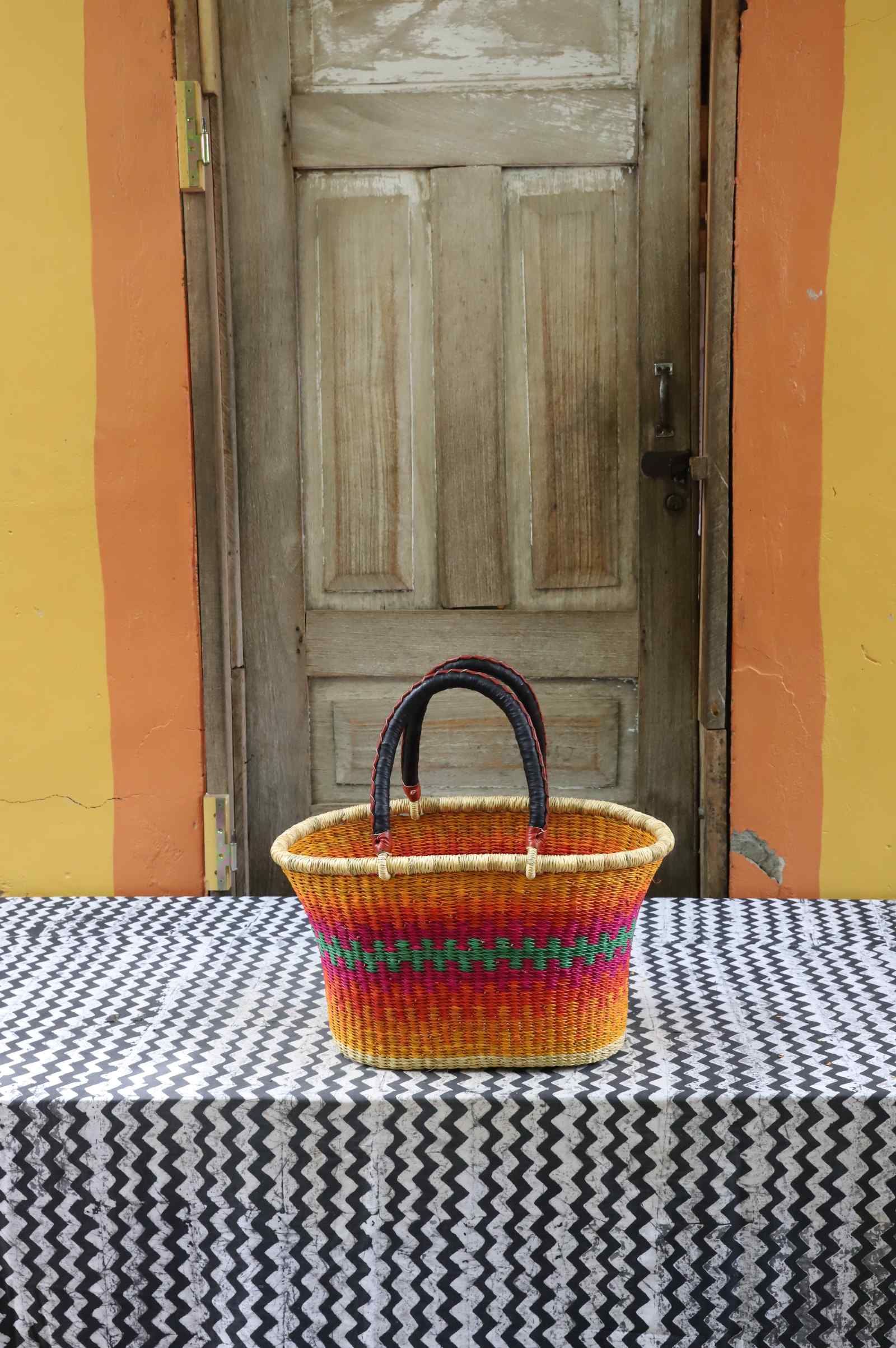 Large handwoven Bolga Zaane Tia market basket in natural straw with multicolour rainbow banded stripes.
