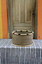 Handwoven Bolga storage basket in natural straw with a bold black geometric weave and twin handles.