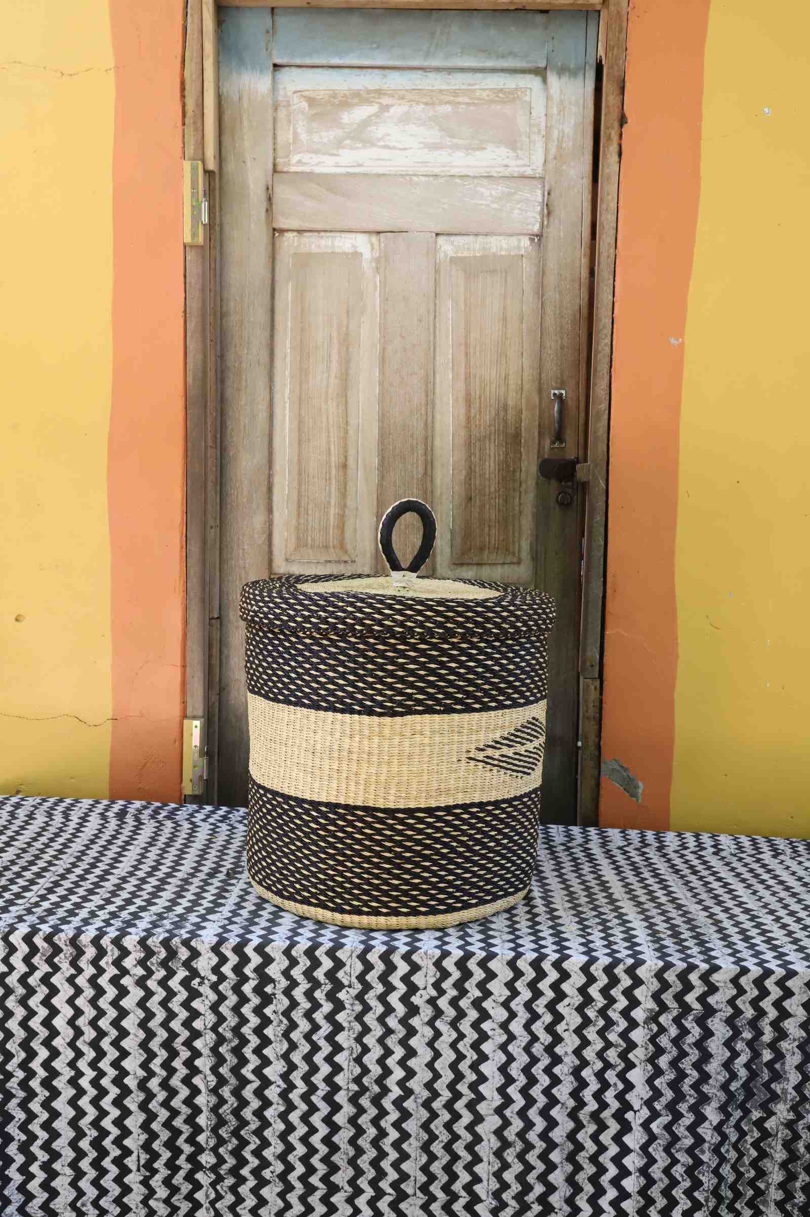 Handwoven Bolga laundry basket with lid in dark elephant grass with a natural straw central band.