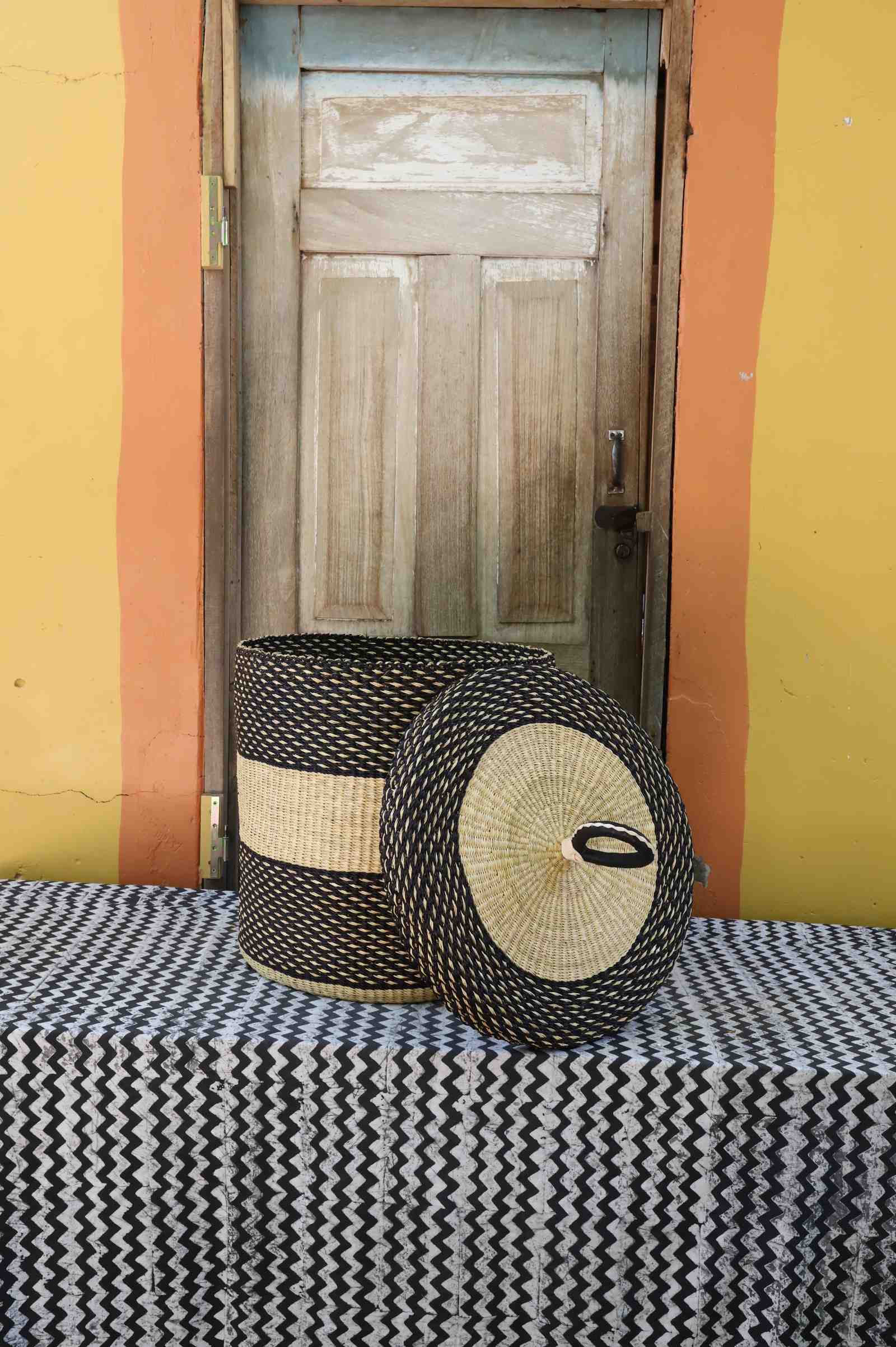 Handwoven Bolga laundry basket with lid removed, dark body with natural central band and matching lid.