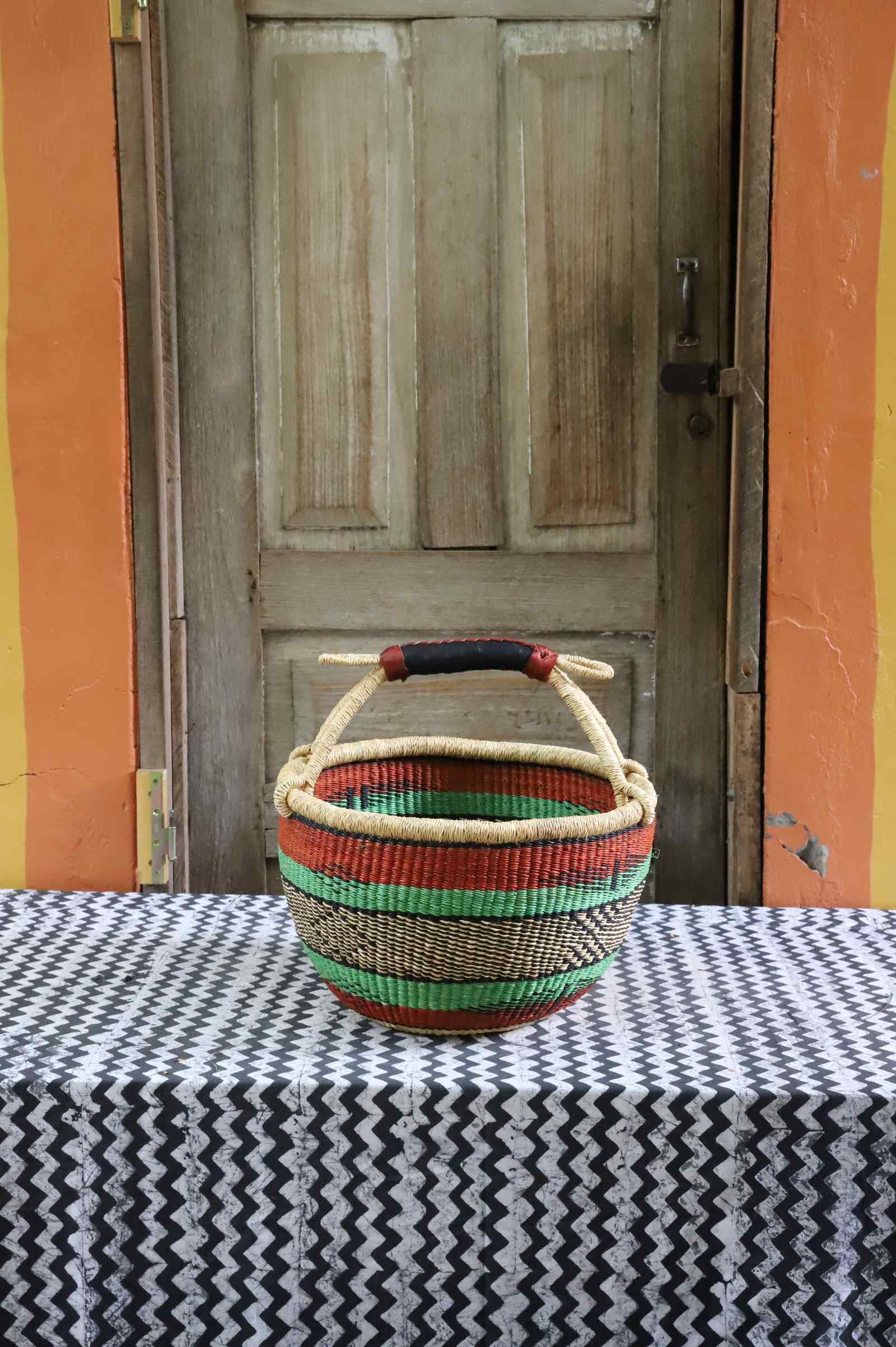 Medium round Bolga basket handwoven in elephant grass, standing 28 cm tall.