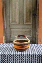 Round shopping basket handwoven in elephant grass, 33 cm wide and 19 cm tall.