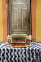 Medium handwoven African basket dog bed in elephant grass, with a front opening.