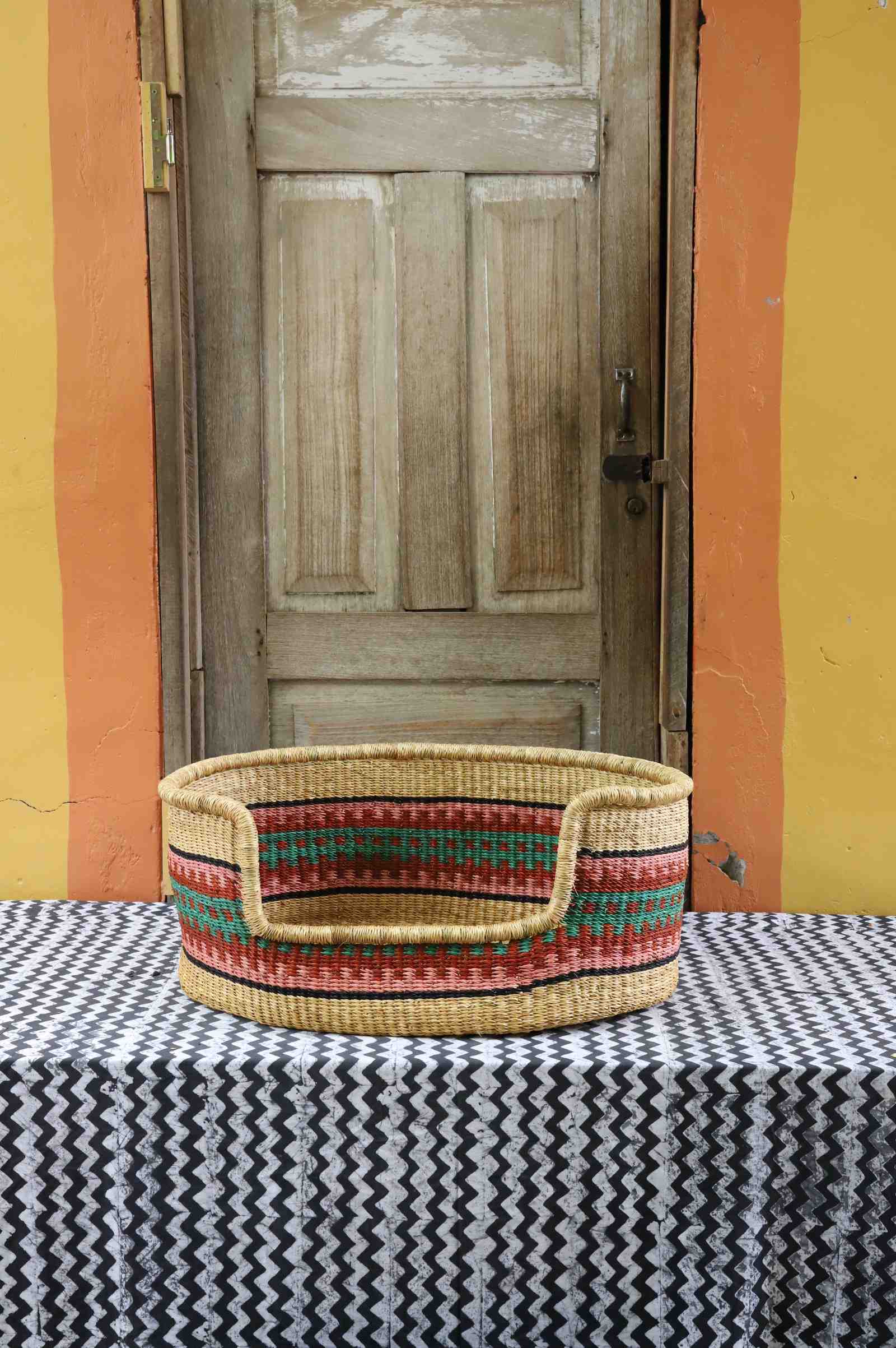 Medium handwoven African basket dog bed in elephant grass, with a front opening.
