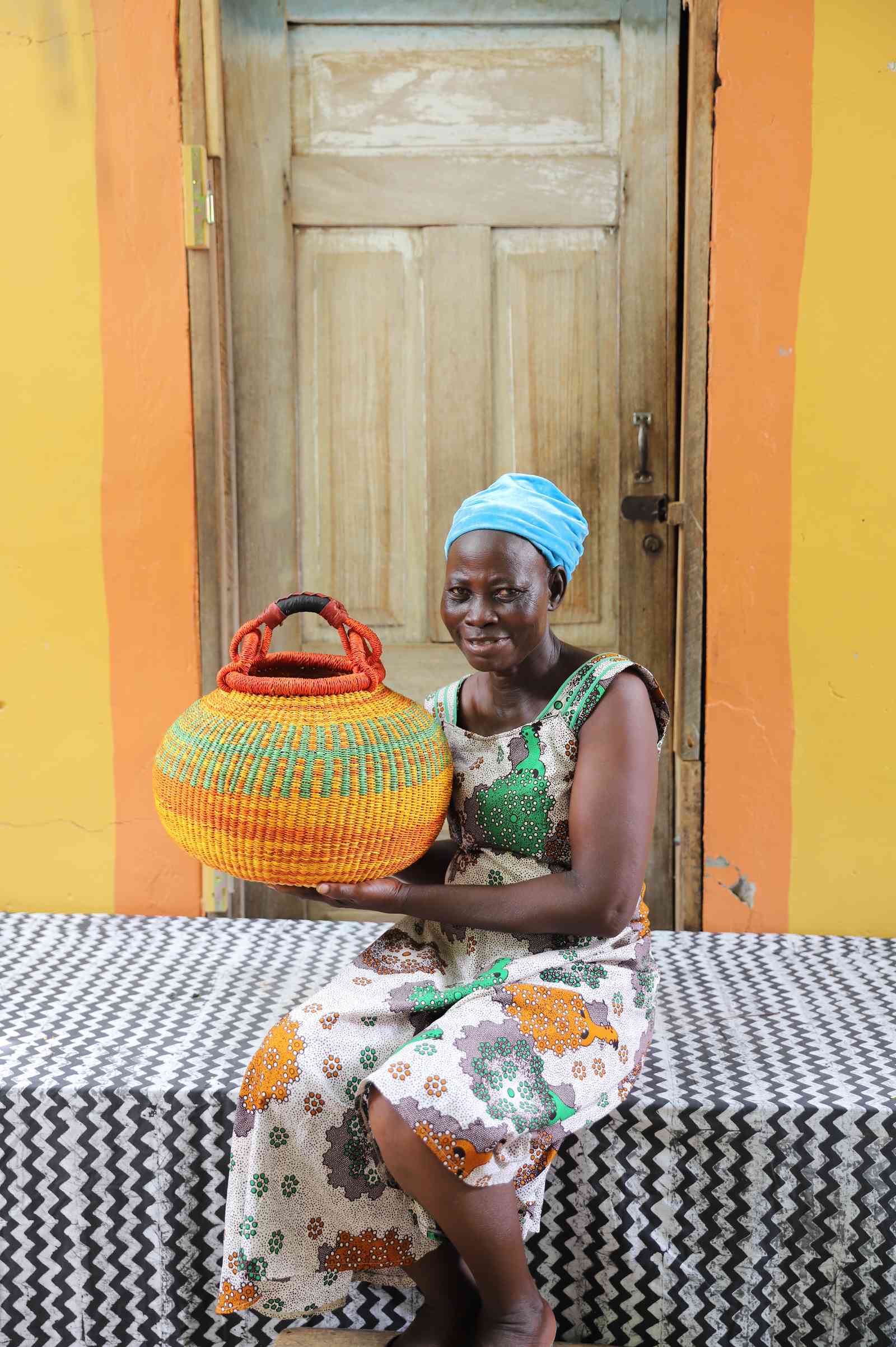 Handwoven Bolga basket in elephant grass with a rounded body and narrow opening.