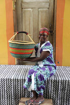 Large handwoven African basket in elephant grass, round and open with two handles.