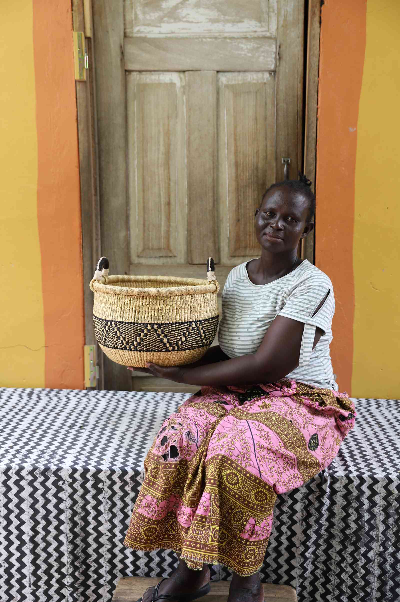 Handwoven African basket in elephant grass, a shallow open form for fruit or textiles.