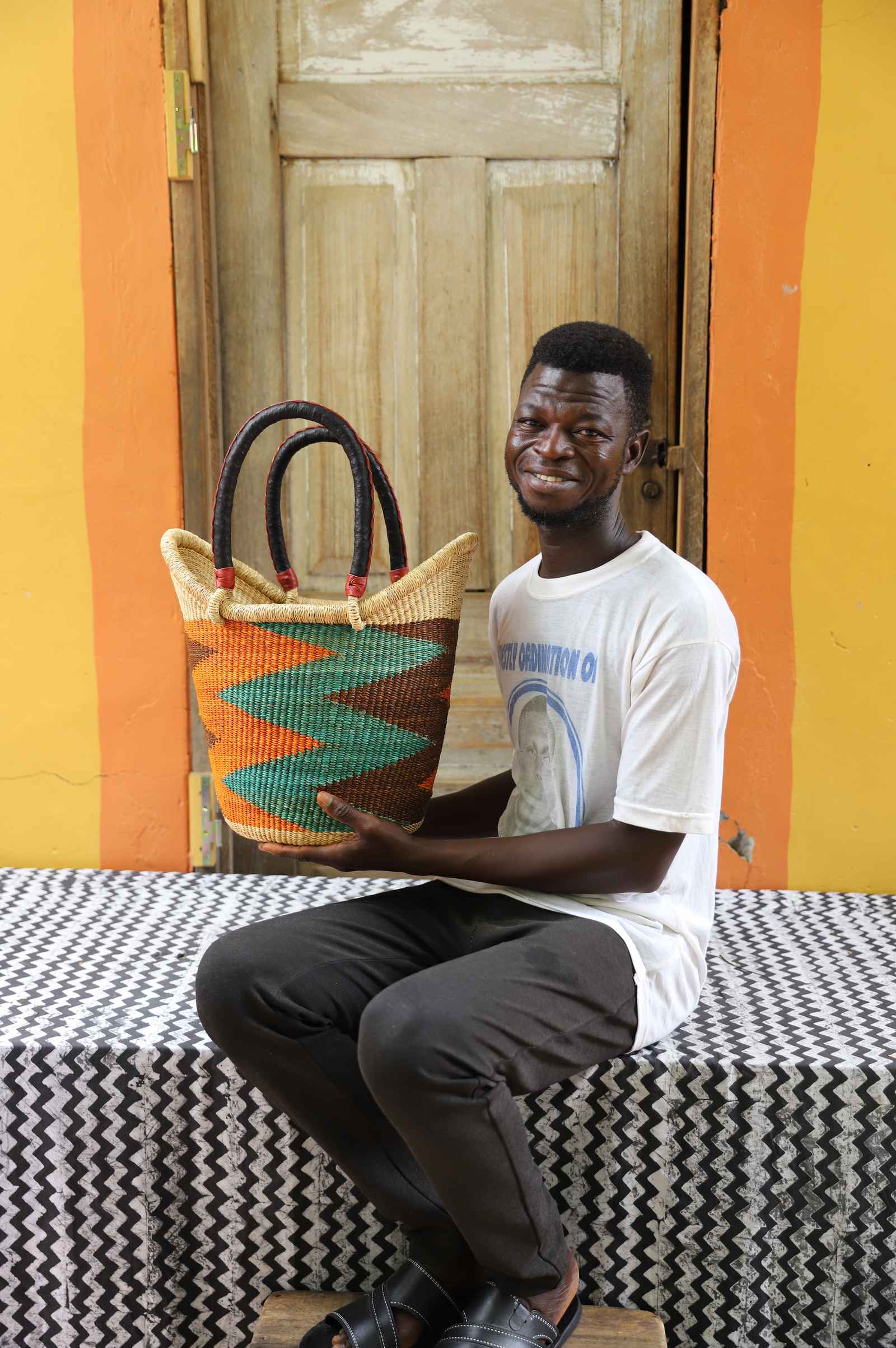 Handwoven African basket carryall in elephant grass, with two handles and a coiled rim.