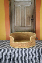 Large handwoven Bolga pet bed in plain natural straw with a subtle diagonal weave.