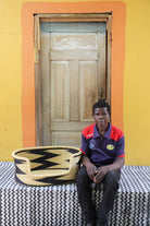 Handwoven African basket dog bed in elephant grass, with a wide low entrance.